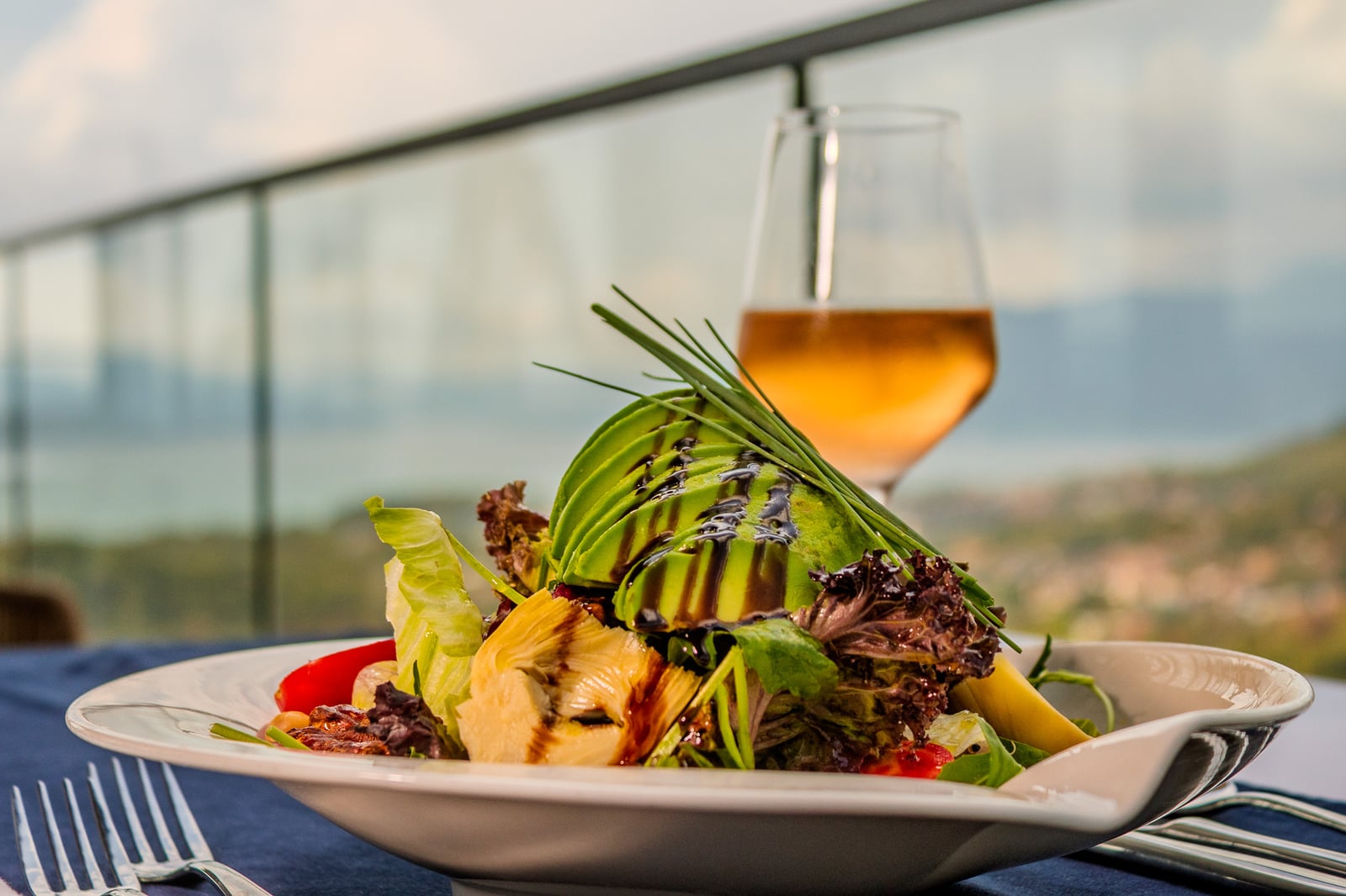 Avocado salad and a glass of wine with a bay view at Cielo
